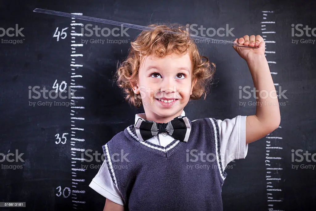 cute-little-boy-measuring-his-height-with-a-ruler.webp.e8af2ea931583bbaed68754b37170756.webp